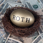 The word "roth" written on a golden egg in a nest on top of a pile of $20 bills